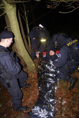15 - policisté ošetřují a balí 2. raněného do termofolie
