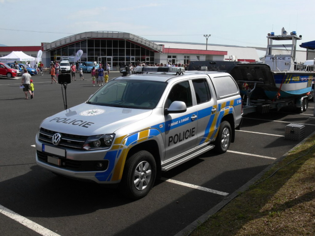 Policejní vozidlo a člun poříčního oddělení